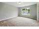 Bedroom with neutral carpet and paint and a window with a view of the neighborhood at 5115 Heathland Dr # 47, Charlotte, NC 28215