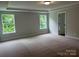 Spacious bedroom with plush carpet, large windows offering serene views, and a tray ceiling at 5115 Heathland Dr # 47, Charlotte, NC 28215