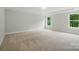 A large, empty bedroom with neutral carpet floors and large windows at 5115 Heathland Dr # 47, Charlotte, NC 28215