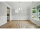 Bright dining room featuring hardwood floors, elegant wainscoting, and natural light from large windows at 5115 Heathland Dr # 47, Charlotte, NC 28215
