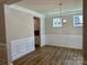 Elegant dining room with decorative wainscoting, hardwood floors, and a stylish chandelier at 5115 Heathland Dr # 47, Charlotte, NC 28215