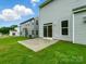 This home showcases a rear view with a small patio and lush green yard at 5115 Heathland Dr # 47, Charlotte, NC 28215