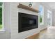 Close-up of the modern fireplace with a wooden mantel and shiplap accent wall at 5115 Heathland Dr # 47, Charlotte, NC 28215