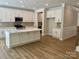 Open kitchen with an island, stainless steel appliances, white cabinets, and hardwood floors at 5115 Heathland Dr # 47, Charlotte, NC 28215