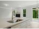 Island kitchen with white cabinets, light countertops, sink, and stainless faucet at 5115 Heathland Dr # 47, Charlotte, NC 28215