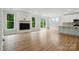 Bright living room featuring wood floors, fireplace, and large windows overlooking a green landscape at 5115 Heathland Dr # 47, Charlotte, NC 28215
