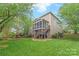 Manicured backyard featuring a screened-in porch, stairs, green grass, garden, and privacy fence at 8905 Valleymoon Ln, Charlotte, NC 28214
