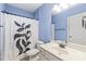 Clean bathroom with a single sink vanity, toilet, shower featuring a decorative black-and-white shower curtain at 8905 Valleymoon Ln, Charlotte, NC 28214
