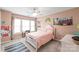 Bright bedroom with neutral walls, carpet floors, and a white bed frame with pink linens at 8905 Valleymoon Ln, Charlotte, NC 28214
