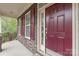 Inviting entryway with stone accents, red door, and decorative shutters create curb appeal at 8905 Valleymoon Ln, Charlotte, NC 28214
