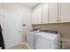 Functional laundry room with cabinets, washer, dryer, and tile floor at 8905 Valleymoon Ln, Charlotte, NC 28214