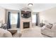 Cozy living room featuring a fireplace, comfortable seating, and lots of natural light from the windows at 8905 Valleymoon Ln, Charlotte, NC 28214