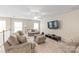 Spacious living room featuring plush seating, a ceiling fan, and a wall-mounted TV for entertainment at 8905 Valleymoon Ln, Charlotte, NC 28214