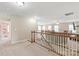 Open loft with a railing overlooking the lower level, featuring a cozy seating area and ample natural light at 8905 Valleymoon Ln, Charlotte, NC 28214