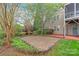 Landscaped backyard with a brick patio, shrubbery, grass, and the exterior of the home with siding at 8905 Valleymoon Ln, Charlotte, NC 28214
