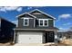 Two-story home with gray siding, stone accents, white trim, and a two-car garage at 102 Obadiah Ct, Troutman, NC 28115