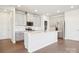 Bright kitchen features white cabinets, stainless steel appliances, and a center island at 102 Obadiah Ct, Troutman, NC 28115