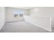 Carpeted loft area with white walls and two windows providing natural light at 102 Obadiah Ct, Troutman, NC 28115