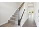 Hallway with staircase featuring carpeted steps and white railings in a modern-style home at 102 Obadiah Ct, Troutman, NC 28115