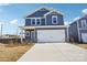 Lovely two-story home with a blue exterior, two-car garage, and a wide concrete driveway at 103 Obadiah Ct, Mooresville, NC 28115