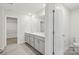 Bathroom with double vanity, gray cabinets, and tiled floors, leading to a walk-in closet at 107 Obadiah Ct, Troutman, NC 28115