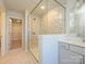 A glass enclosed shower with marble patterned walls next to a marble tiled floor at 149 Halite Ln, Waxhaw, NC 28173