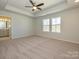 Large primary bedroom featuring tray ceilings, ceiling fan and ensuite bath at 149 Halite Ln, Waxhaw, NC 28173