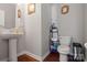 Cozy powder room featuring pedestal sink, wood floors, and decorative wall hangings at 8007 April Ln, Matthews, NC 28104
