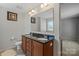 Bright bathroom with double sinks, granite countertops, large mirror, and wood cabinets at 8007 April Ln, Matthews, NC 28104