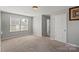 Comfortable bedroom with a window, neutral walls, carpet, and a white door at 8007 April Ln, Matthews, NC 28104
