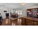 Open-concept dining area with hardwood floors, a chandelier, and an adjacent office space at 8007 April Ln, Matthews, NC 28104