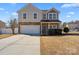 Charming two-story home featuring stone accents, a two-car garage, and a well-maintained front yard at 8007 April Ln, Matthews, NC 28104