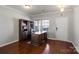 Bright home office with a large wooden desk, hardwood floors, and a built-in bookcase at 8007 April Ln, Matthews, NC 28104