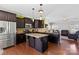 Gourmet kitchen featuring stainless steel appliances, granite countertops, island, and dark wood cabinetry at 8007 April Ln, Matthews, NC 28104