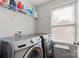 Laundry room featuring front loading machines, shelving, and natural light at 8007 April Ln, Matthews, NC 28104
