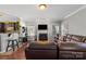 Cozy living room with a fireplace, hardwood floors, comfortable leather seating and bar at 8007 April Ln, Matthews, NC 28104