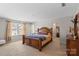 Spacious primary bedroom with a large bed, carpeted floors, and an ensuite bathroom at 8007 April Ln, Matthews, NC 28104