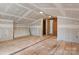 Unfinished attic renovation project featuring exposed beams and a doorway to a brick wall room at 841 12Th Nw Ave, Hickory, NC 28601