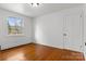This bedroom has hardwood floors and a window that provides a view of the neighborhood at 841 12Th Nw Ave, Hickory, NC 28601