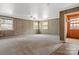 Spacious living room with multiple windows, wood paneled walls, neutral carpeting, and closet at 841 12Th Nw Ave, Hickory, NC 28601