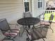 Outdoor porch seating area with metal table and chairs with striped cushions at 120 W Edinburgh Ct, Statesville, NC 28625