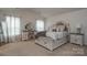 Bright bedroom featuring a vanity, plush carpeting, and a comfortable bed with stylish bedding at 318 Kingsford Dr, Stanley, NC 28164