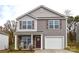 Charming two-story home with a welcoming porch and attached one car garage at 318 Kingsford Dr, Stanley, NC 28164