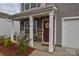 Inviting front porch with rocking chairs and a decorative wreath on the front door at 318 Kingsford Dr, Stanley, NC 28164