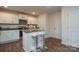 Well-lit kitchen with white cabinets, an island with seating, and sleek appliances at 318 Kingsford Dr, Stanley, NC 28164