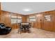 Bright dining area with wood paneling, a round table with seating, and natural light from large windows at 4501 Taylorsville Hwy, Statesville, NC 28625