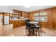 Cozy dining area featuring wood paneling, a round table with black chairs, and light-filled windows at 4501 Taylorsville Hwy, Statesville, NC 28625