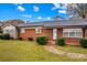 Close-up of a brick home featuring a well-manicured lawn and an inviting front entrance with shrubbery at 4501 Taylorsville Hwy, Statesville, NC 28625