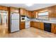 Well-lit kitchen featuring white appliances, wood cabinetry, and modern flooring at 4501 Taylorsville Hwy, Statesville, NC 28625