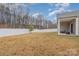 Home's fenced backyard featuring manicured lawn and covered patio seating area at 654 Saddlebred Ln, Locust, NC 28097